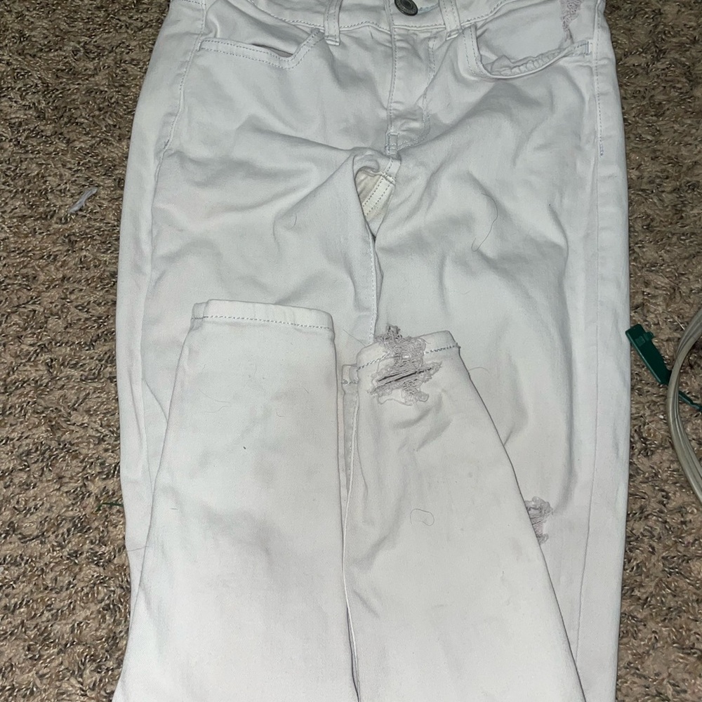 Women American eagle jeans size 2 white with distress on leg and back pocket.